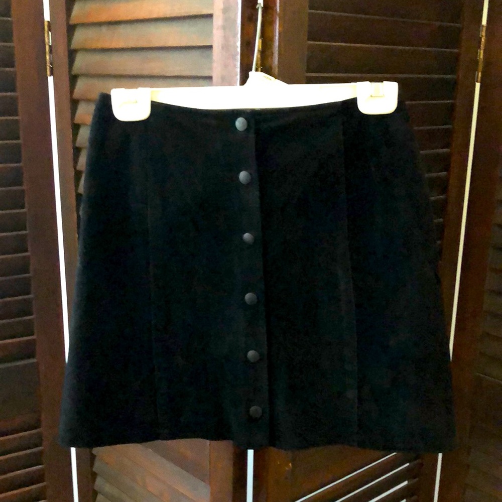 Black Suede mini skirt. Size 6 just above the knee. Snaps up the front.